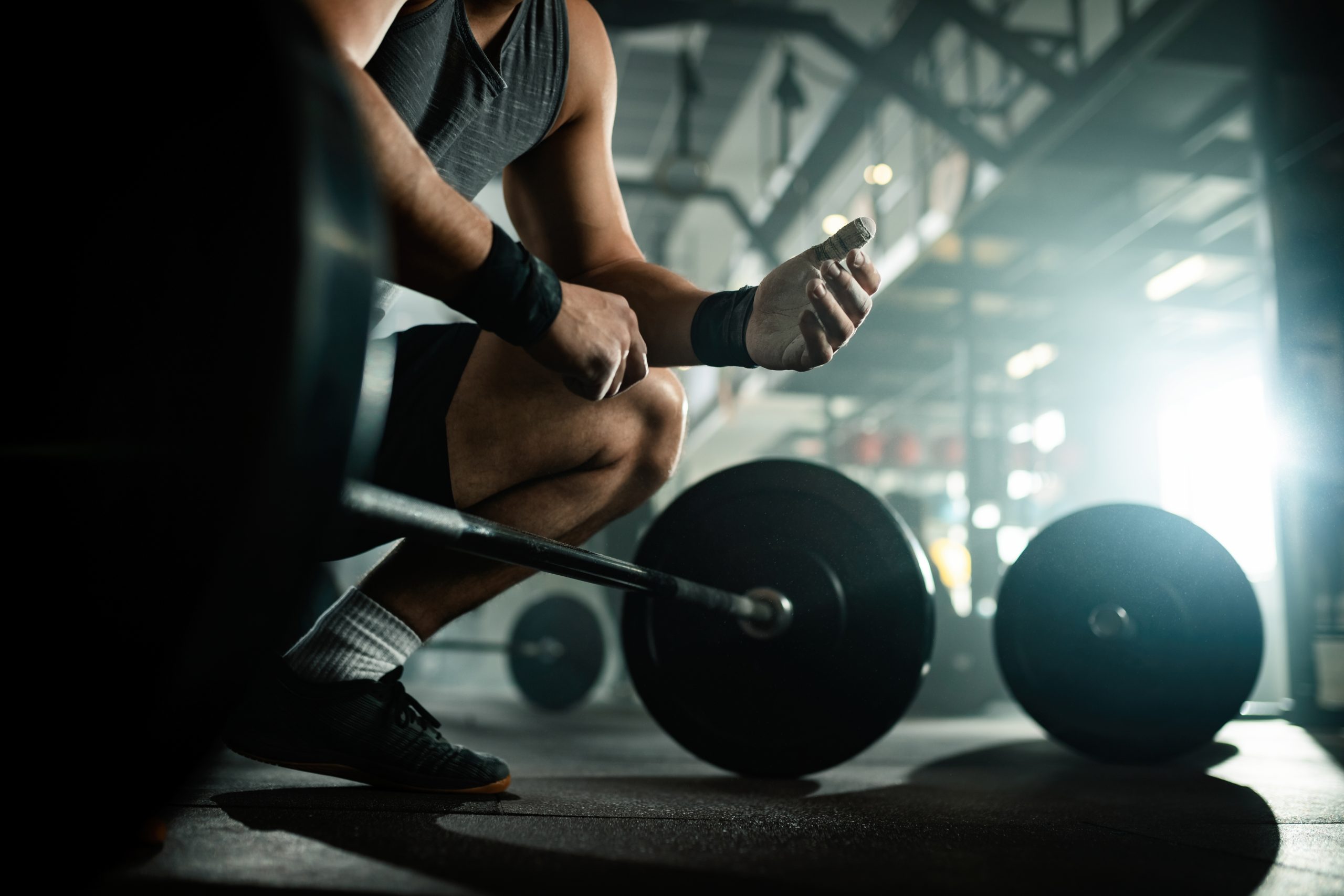 Man preparing to lift barbell in gym