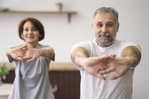 Medium shot adults stretching indoors